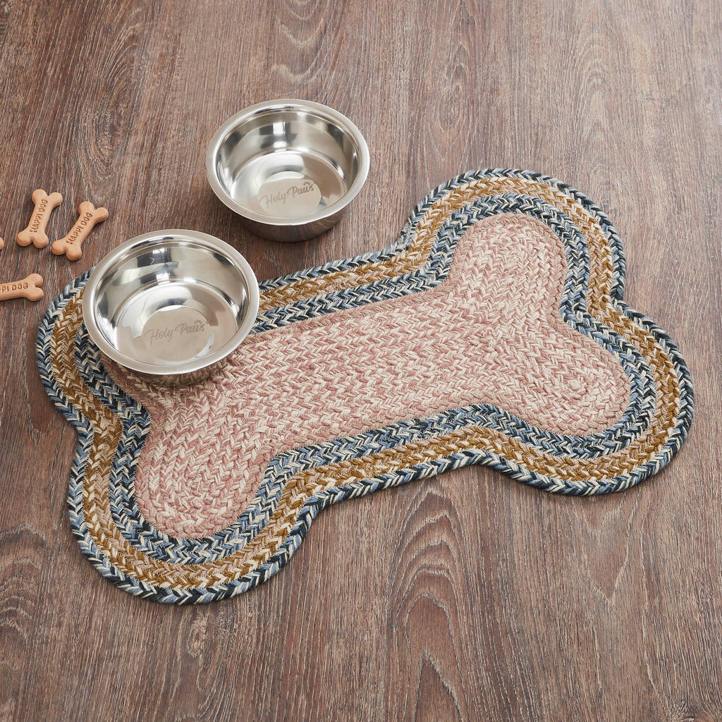 Dog bone-shaped mat with two metal bowls on a wooden surface.