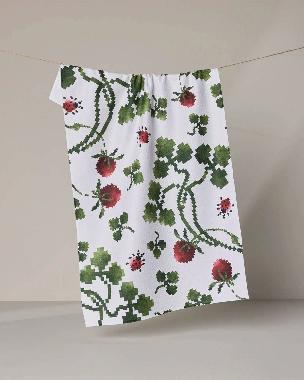 Floral patterned towel hanging on a line against a neutral background