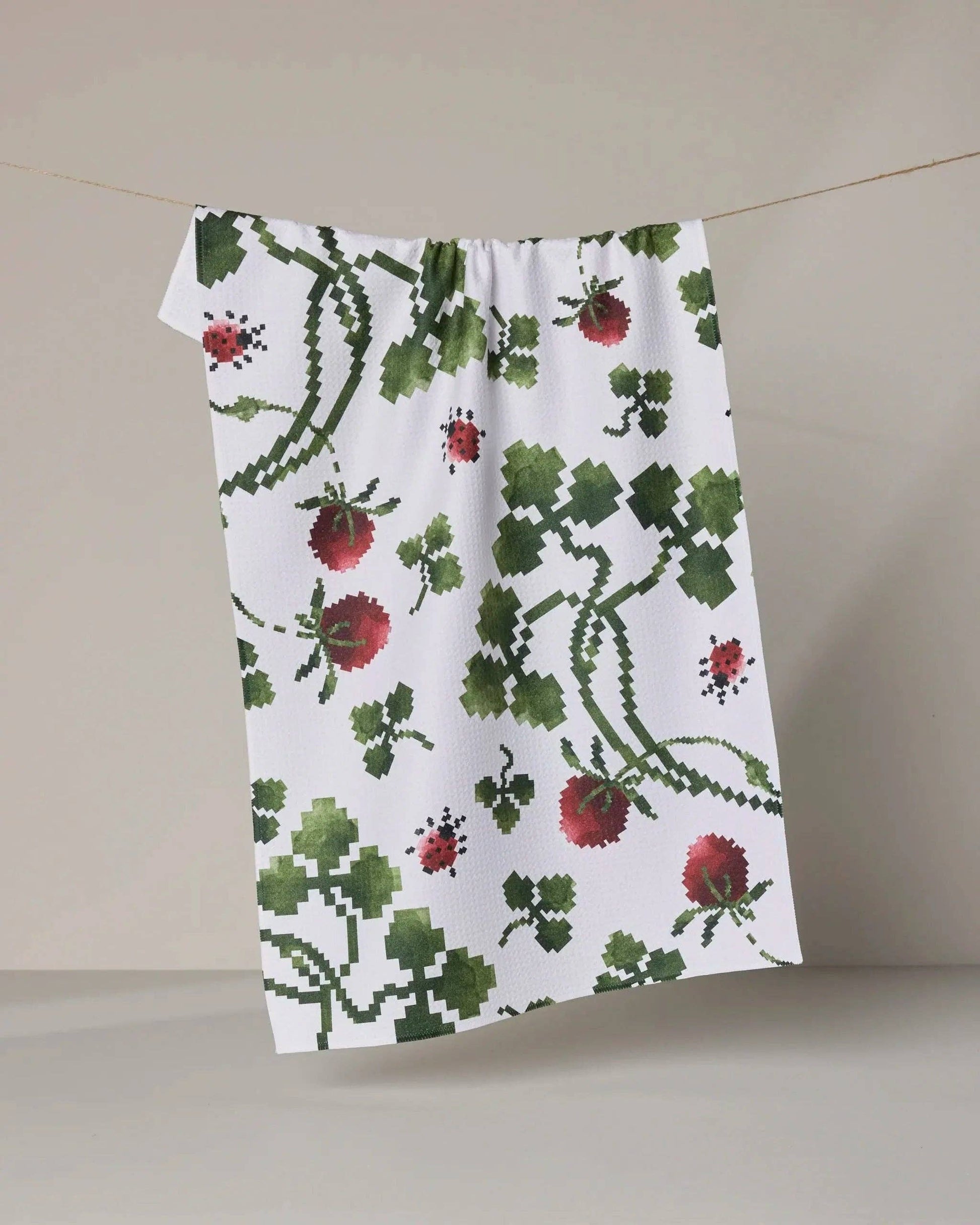 Floral patterned towel hanging on a line against a neutral background