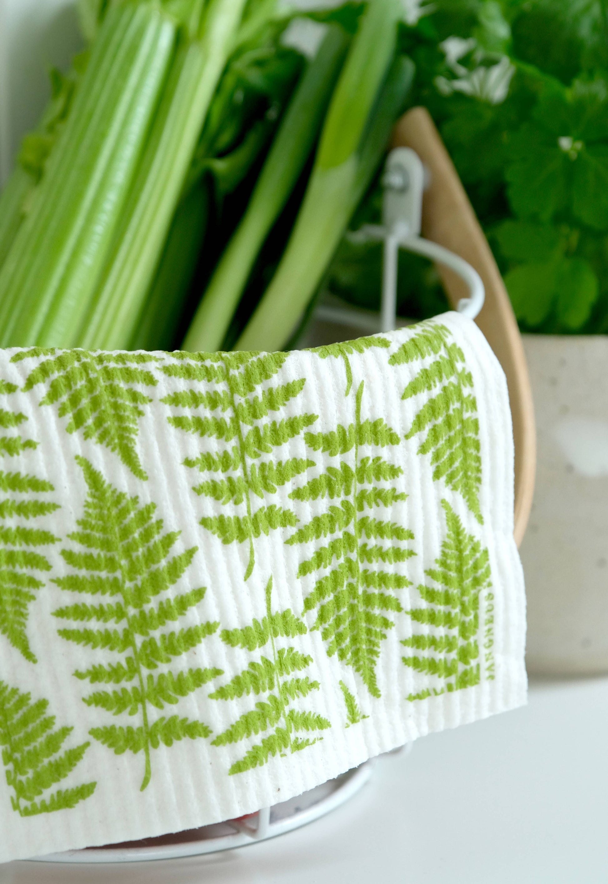 Green leafy towel with a fern pattern on a white surface