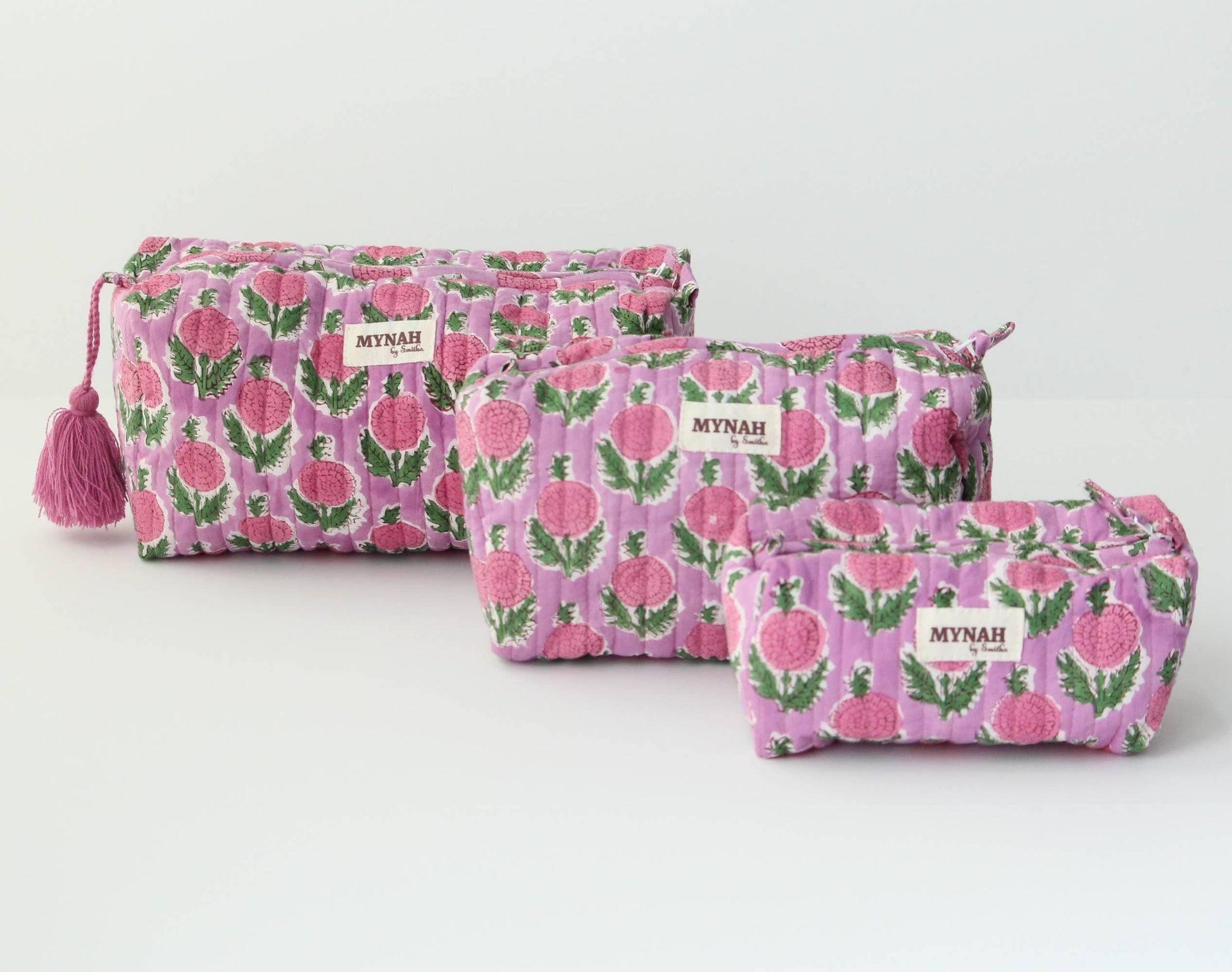Three pink floral pouches with 'Mynah' branding on a white background