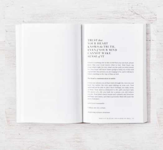 Open book with text on a light wooden surface