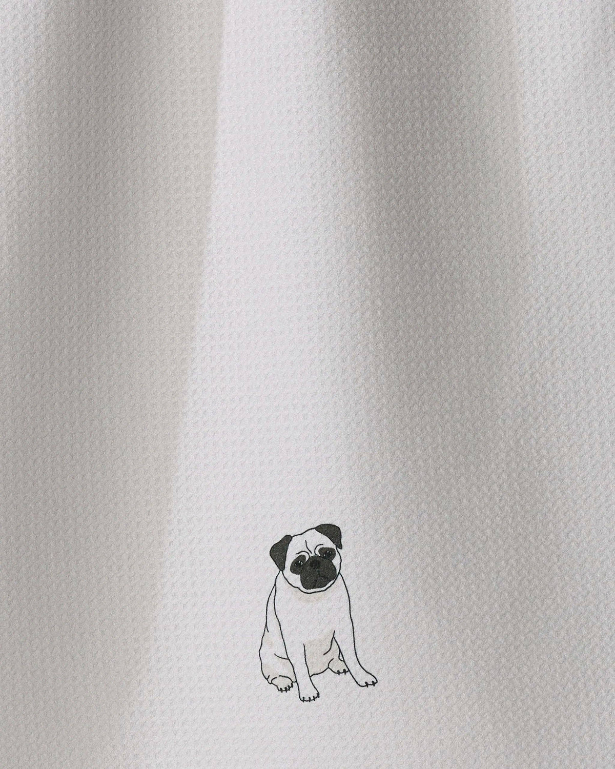 Close-up of a white textured fabric with a small black line-art illustration of a pug near the bottom center.