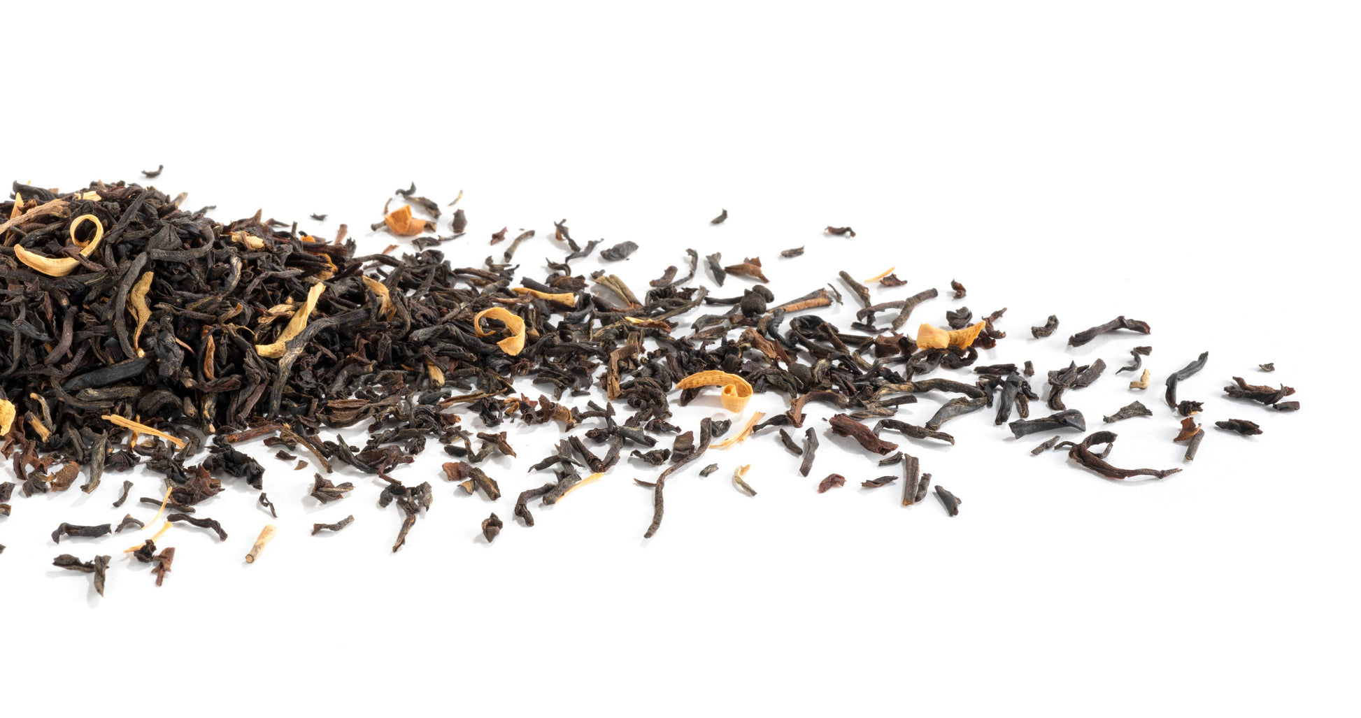 Black tea leaves scattered on a white background
